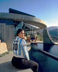 Person wearing an Argentina soccer jersey with a pool and modern architecture in the background